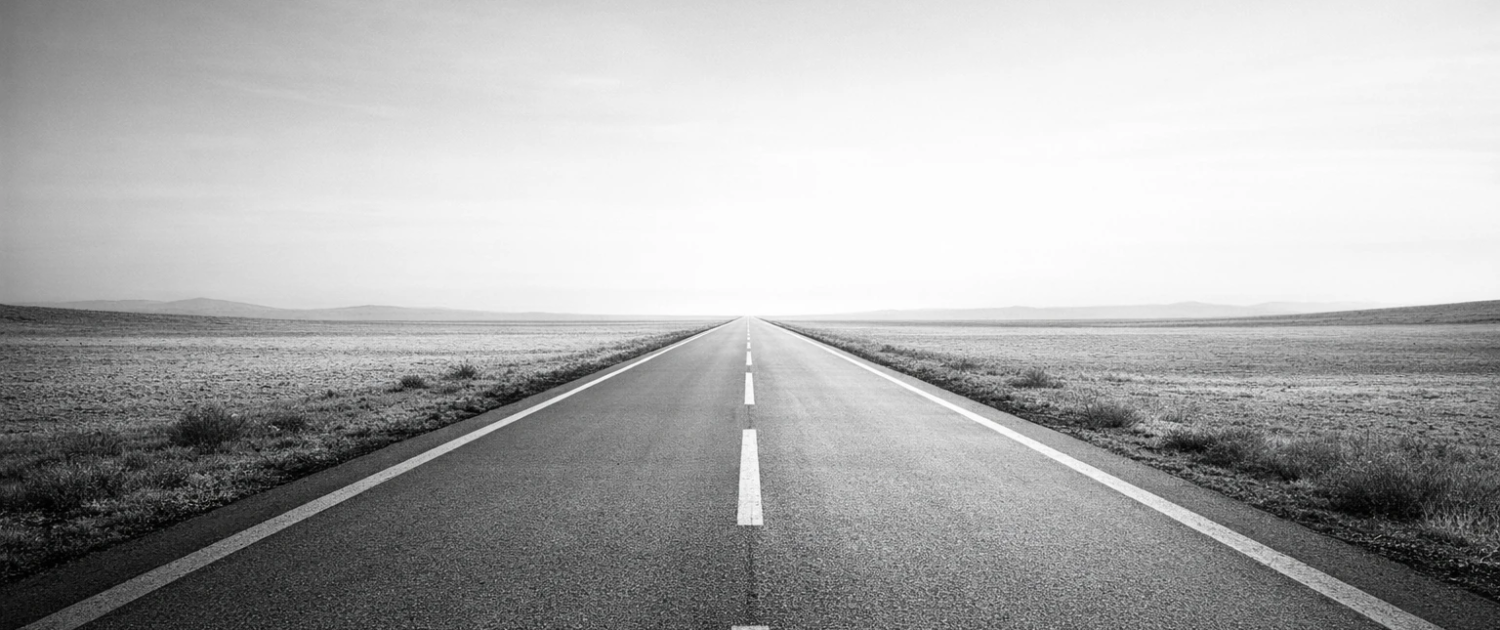 Carretera en blanco y negro que simboliza el camino hacia soluciones industriales, soluciones digitales con IA aplicada, y planificación y protección financiera para pymes, autónomos y particulares